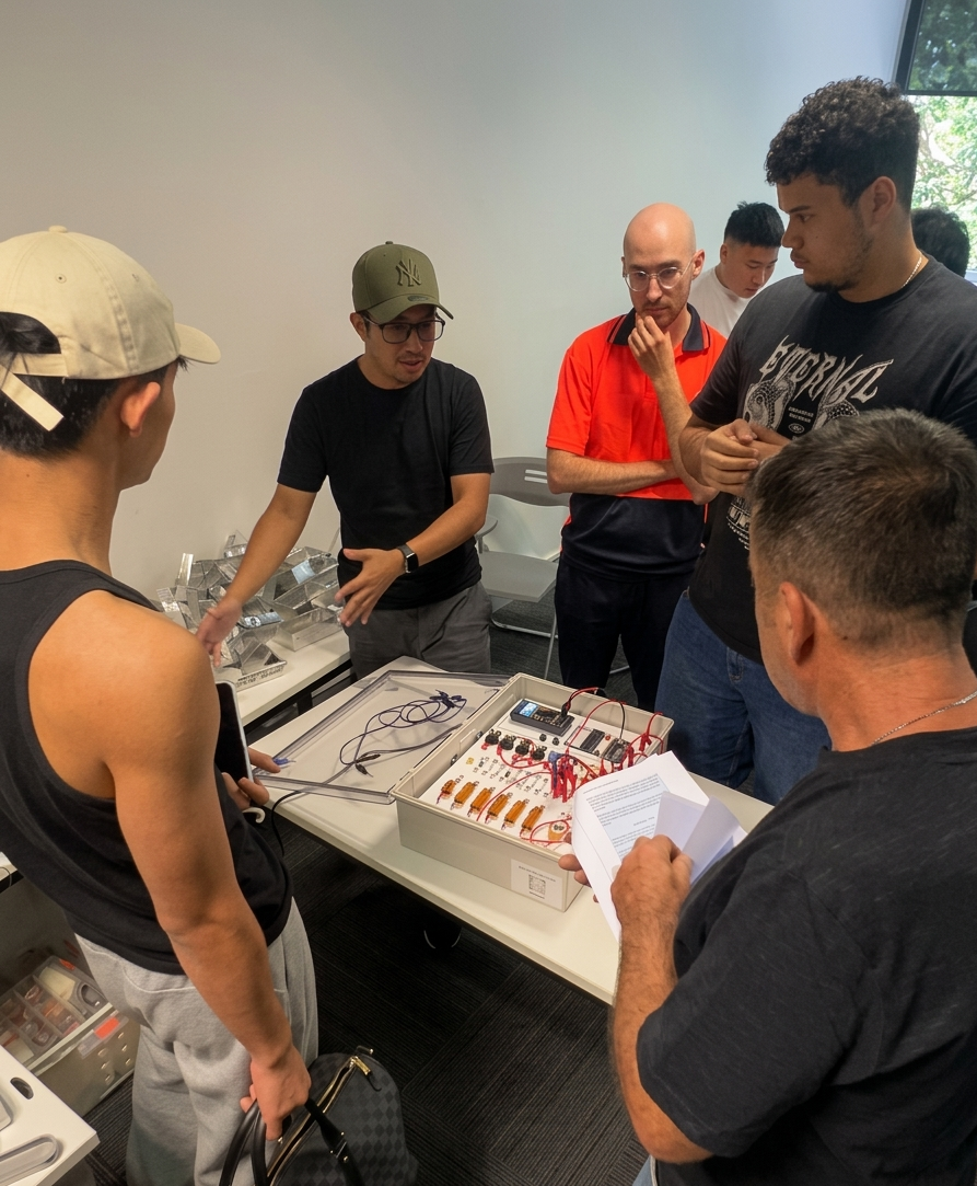 Instructor demonstrating an electrical test board to a small group of Rosehill College students